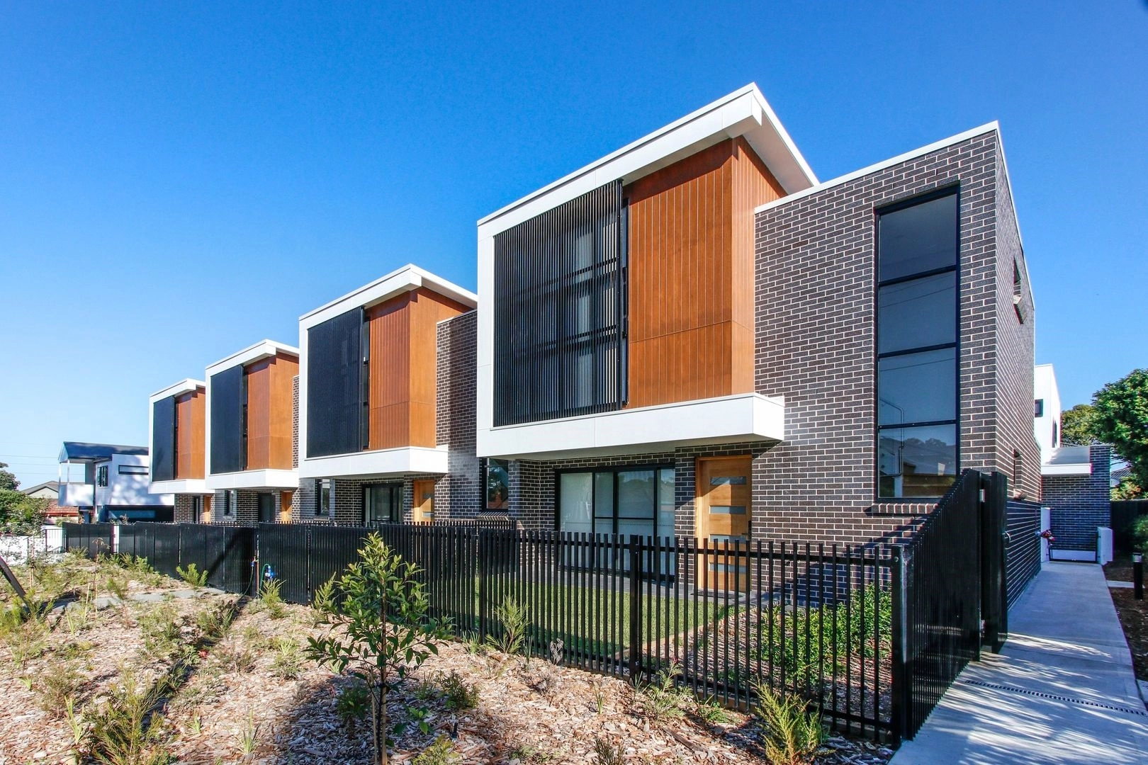 Modern townhouse development with brick and timber exterior design