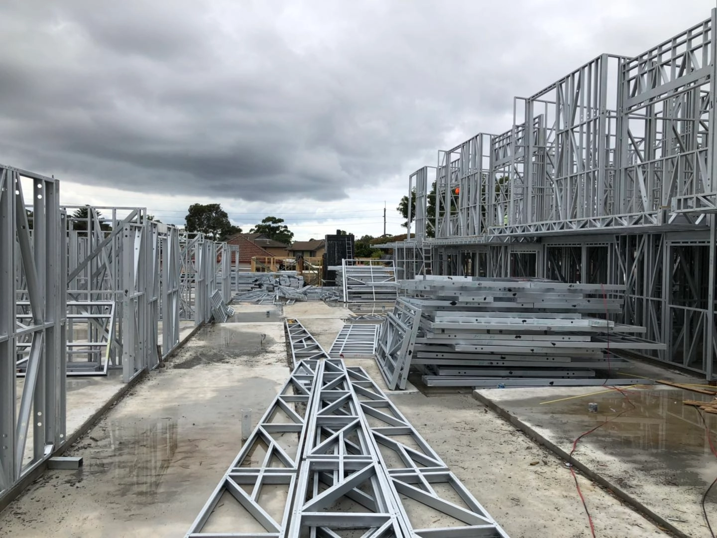 Steel frame construction materials and ground-level assembly for a multi-unit building