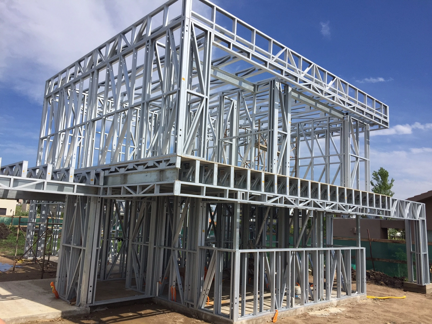 A two level house structure made of light steel framing under a clear sky